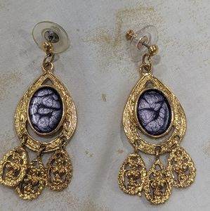 Bohemian gold chandelier earrings with purple center.  Light in ears.
